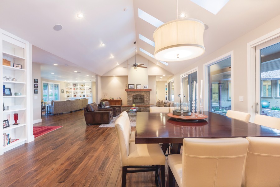 An open concept living room/dining room with in-ceiling speakers, skylights, and smart lighting throughout.